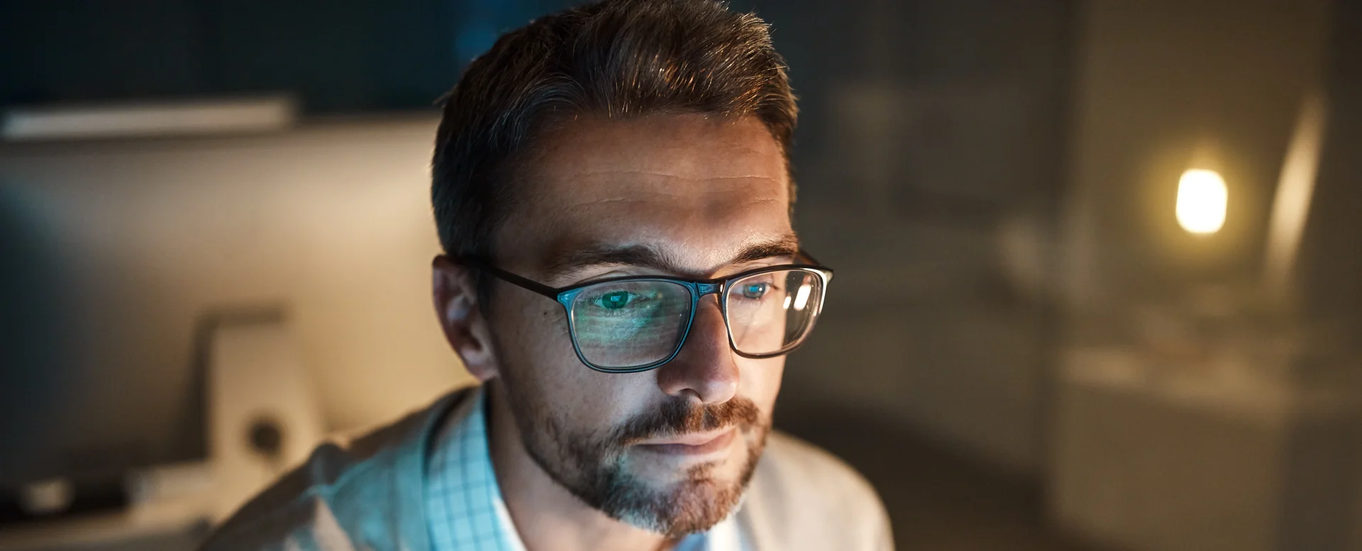 Ein Mann mit Brille und Bart sitzt vor einem Bildschirm